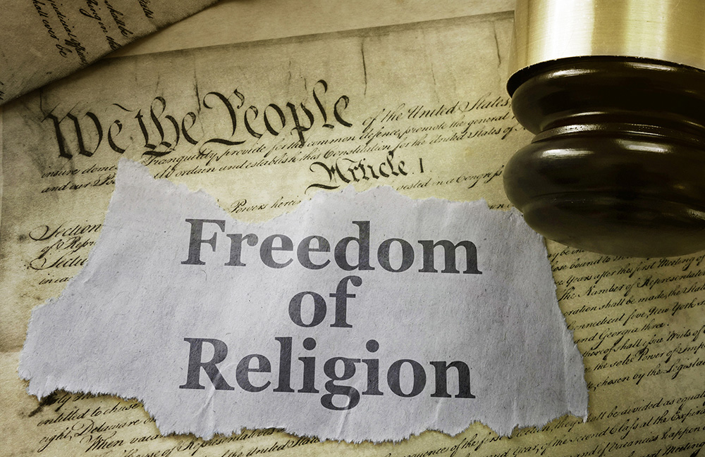 Freedom of Religion newspaper headline on a copy of the US Constitution with gavel